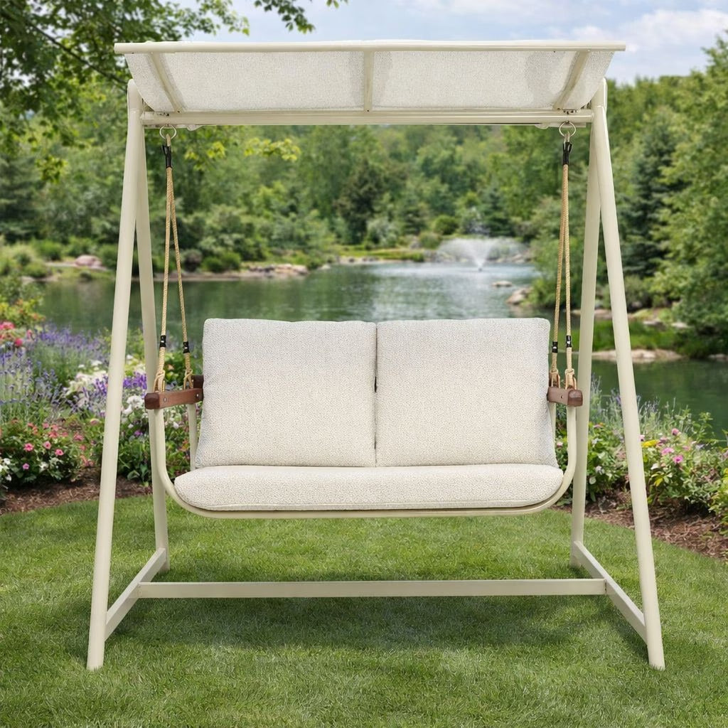 Cream 2-seater outdoor patio swing chair with sturdy aluminum frame and comfortable fabric cushions for garden lounging.