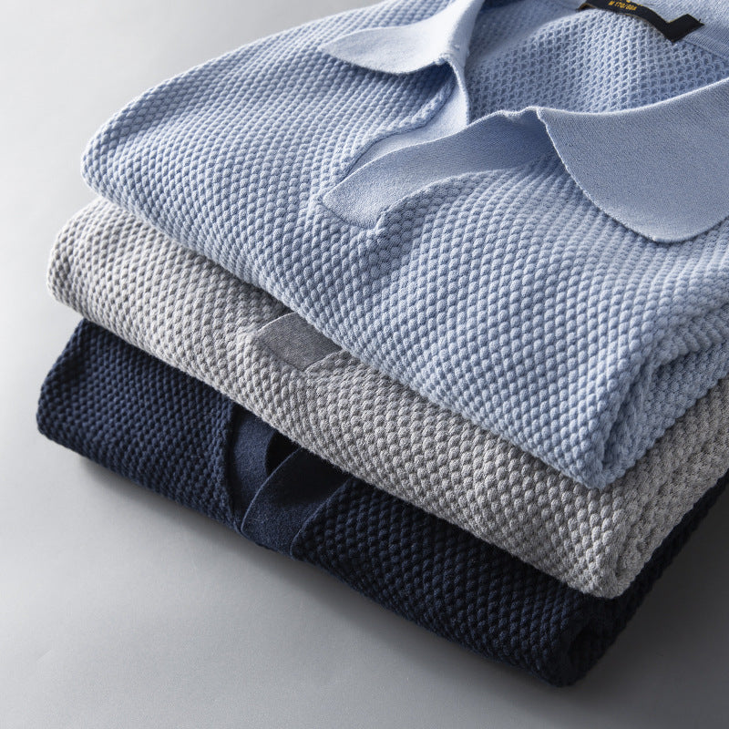 Display of multiple men's premium polo shirts in sky blue, navy, gray, olive green. Tailored & breathable.