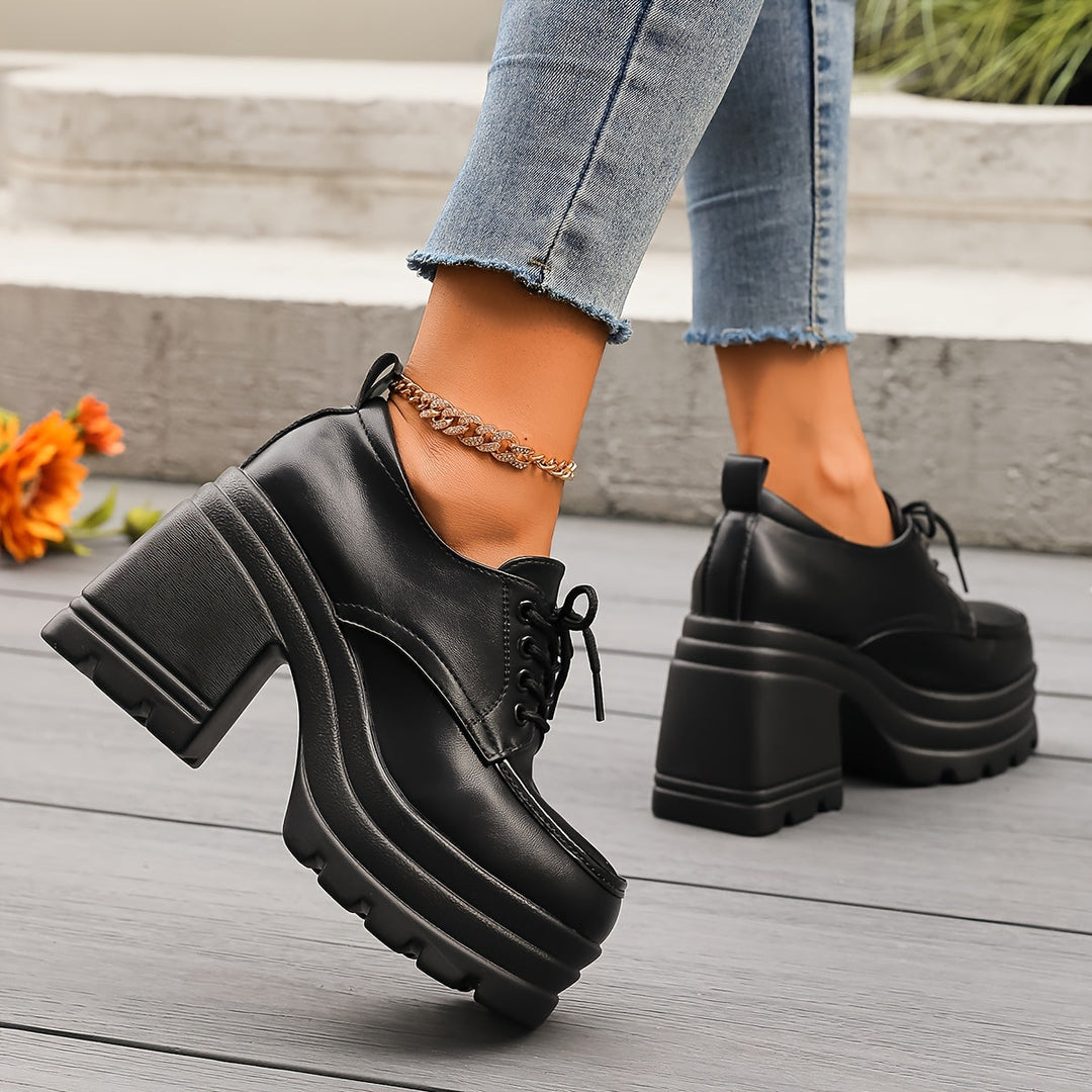 Black women's chunky platform oxfords featuring a sturdy block heel and classic lace-up closure.