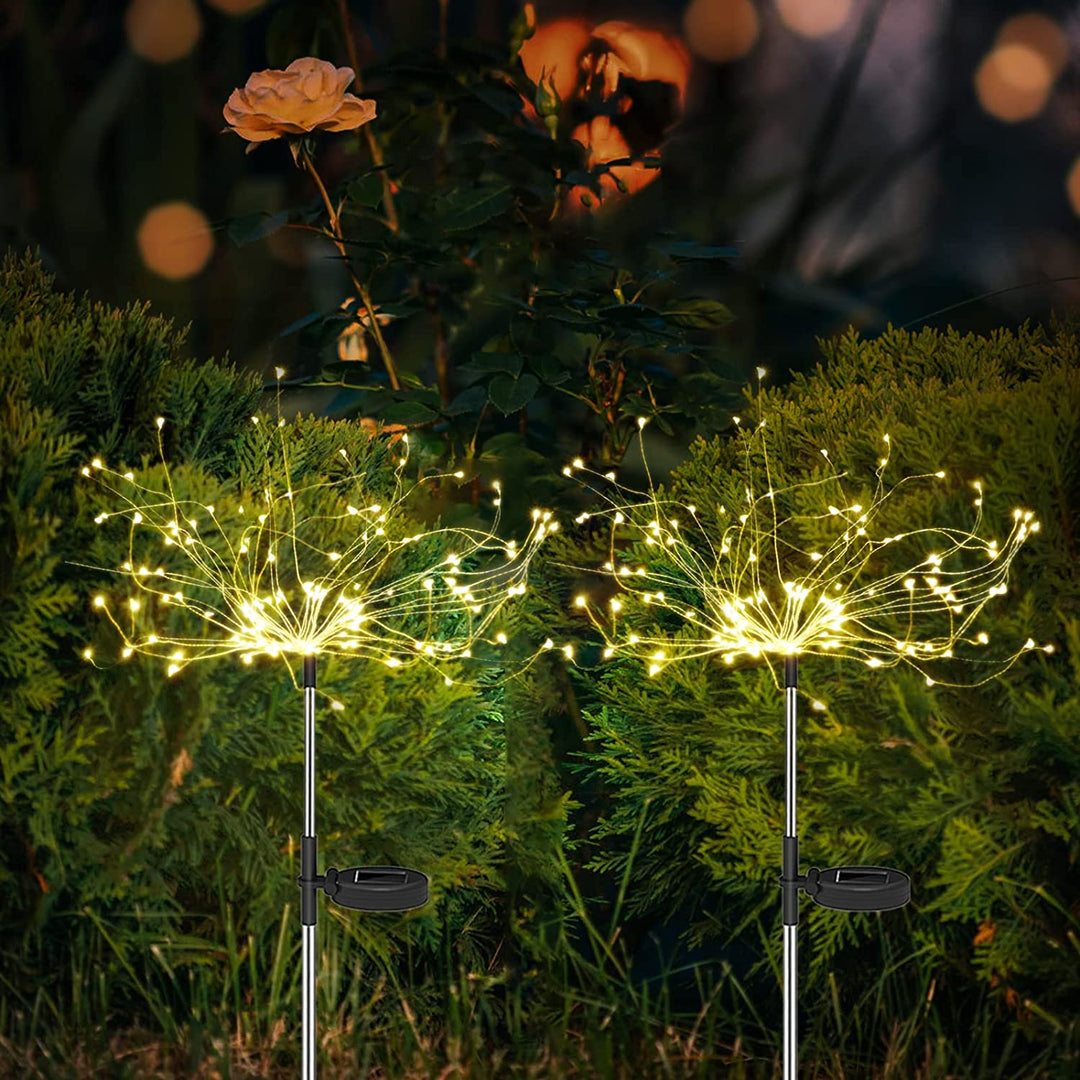Four solar firework lights arranged in a lawn, enhancing garden aesthetics with LED lighting