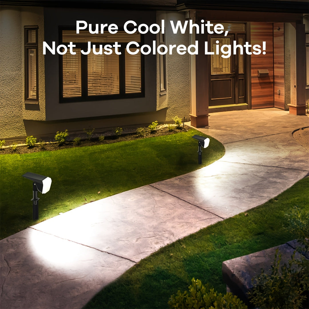 Bright RGB solar LED spotlights illuminating a garden path at night, vibrant outdoor lighting.