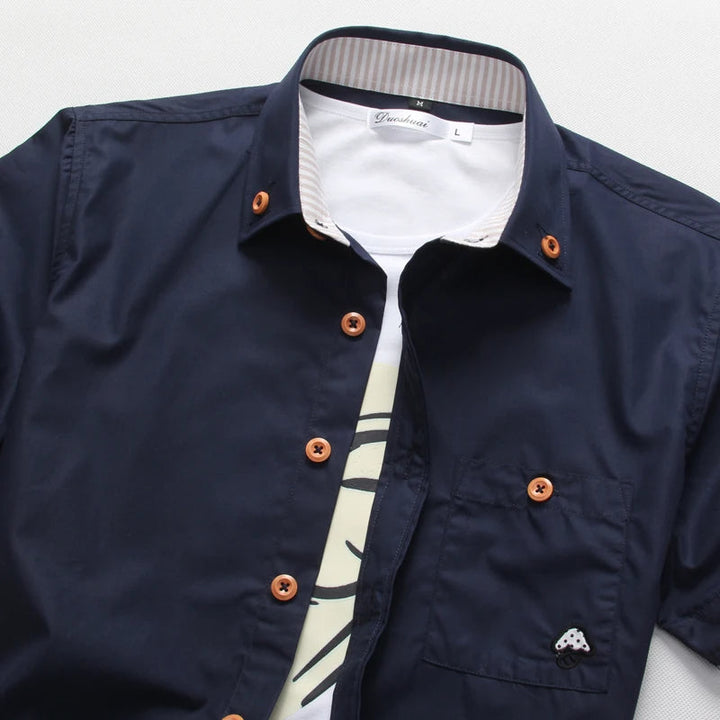 Close-up of men's short sleeve button-up shirt, highlighting unique contrast stitching and buttons.
