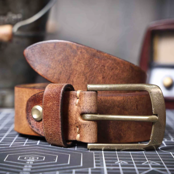 Close-up of a men's full grain brown leather belt showing texture and quality.