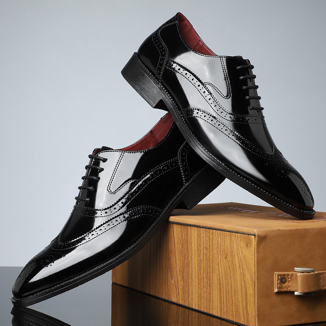 Detailed view of men's leather brogue wingtip dress shoes, emphasizing classic perforations.