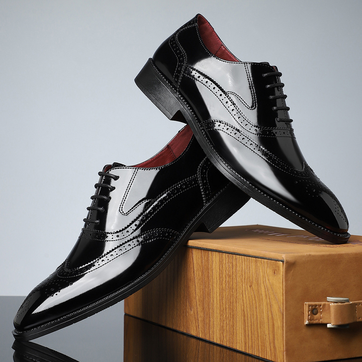 Detailed view of men's leather brogue wingtip dress shoes, emphasizing classic perforations.