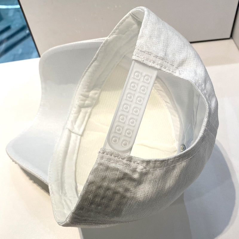 Silver glitter baseball cap, reflecting light with an eye-catching sparkle, ideal for festive fashion.
