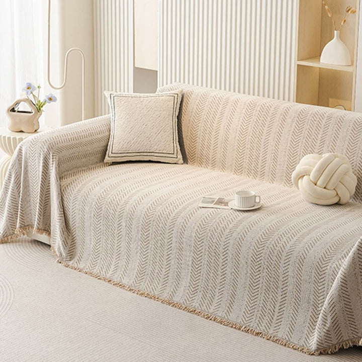 Plush chenille scratch-resistant sofa cover in a neutral tone, protecting living room furniture from pets & spills. Washable slipcover.