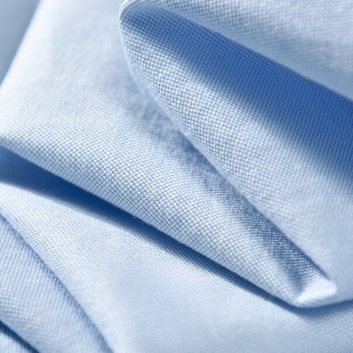 Neatly folded men's long-sleeve collared shirt. Classic button-up for smart casual everyday style, men's essential.