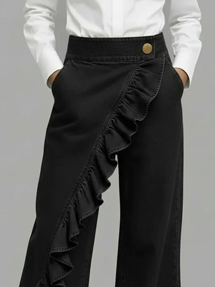 Woman posing in modern high-rise wide leg jeans featuring unique ruffle detail. Stylish casual statement pants.