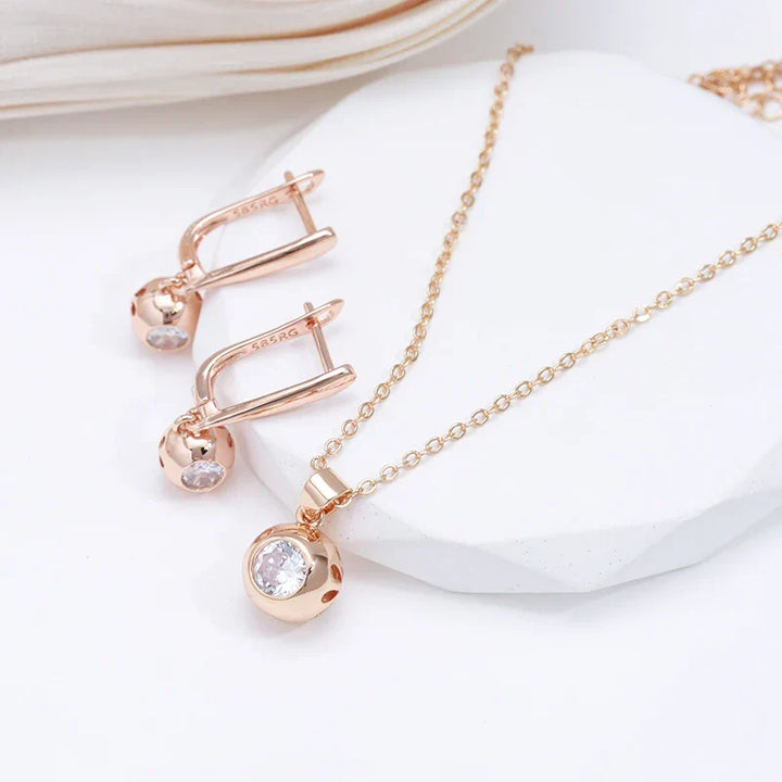 Model wearing an elegant women's rose gold zircon orb necklace and earrings jewelry set.