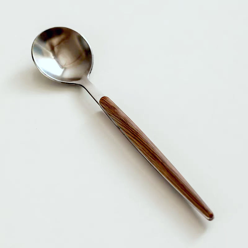 Contemporary glass mug with a contrasting wooden handle, perfect for hot beverages and home decor.