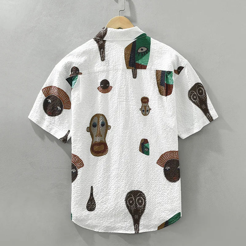 Close-up: Men's Oruka abstract tribal art shirt, cubist design. Unique short sleeve top for expressive style.