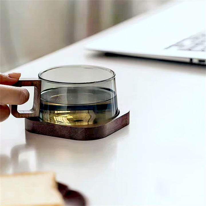 Elegant glass coffee mug featuring a unique ergonomic wooden handle for comfortable grip.