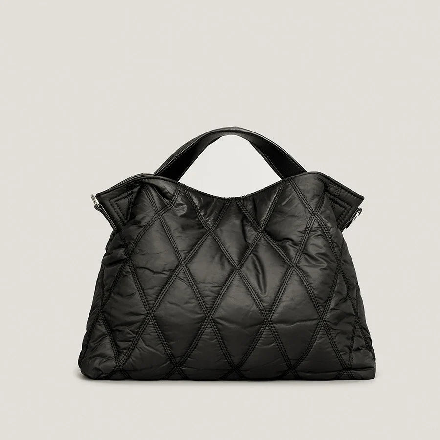 Plush black quilted tote bag for women, spacious & stylish, perfect for everyday carry. A comfortable shoulder handbag.