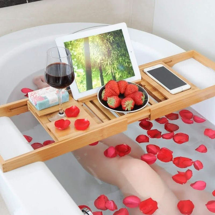 Unisex adjustable bamboo bathtub caddy for books, tablet & drinks. Enhances spa relaxation & self-care.