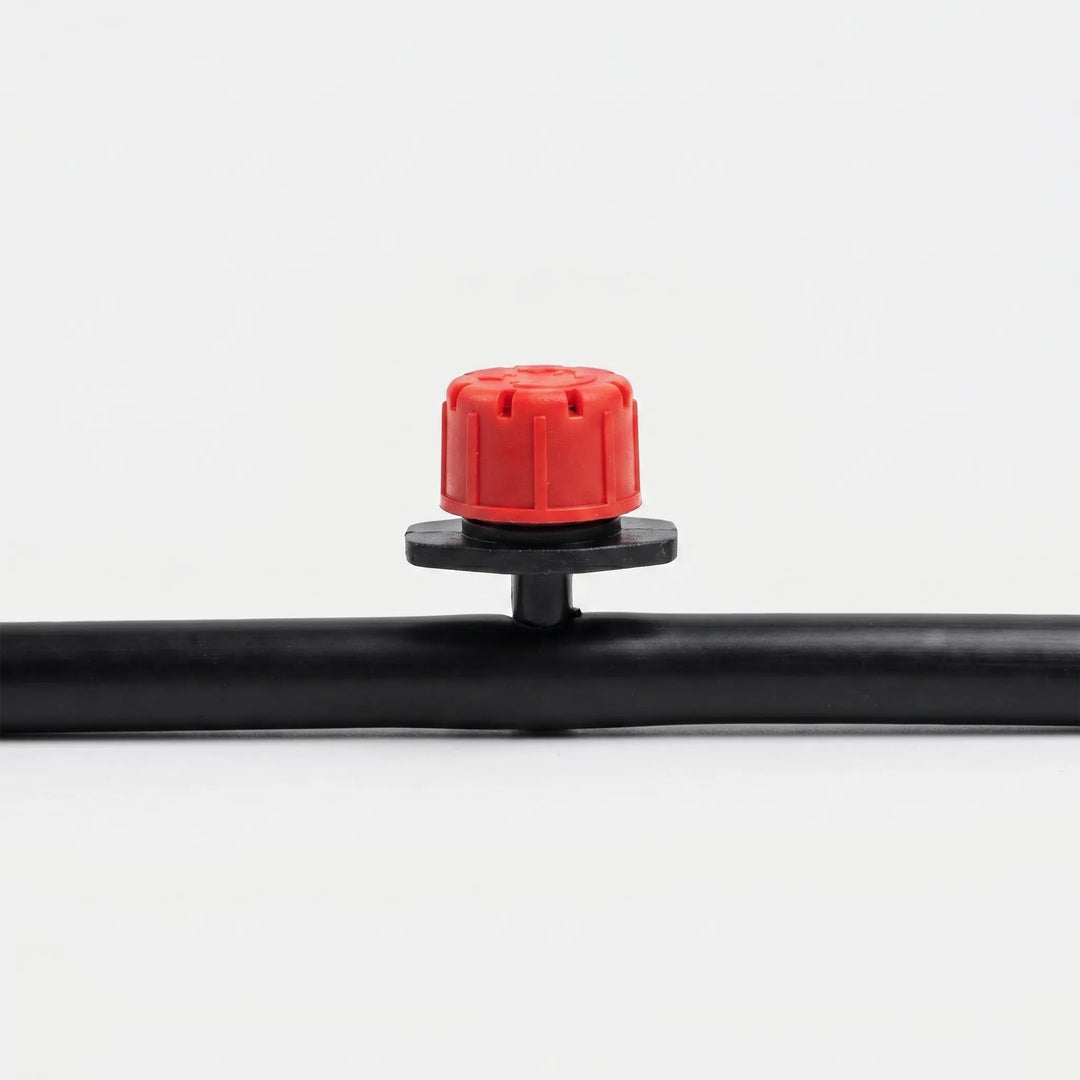 Close-up of black adjustable micro drip irrigation emitters for precise plant watering in gardens & greenhouses.