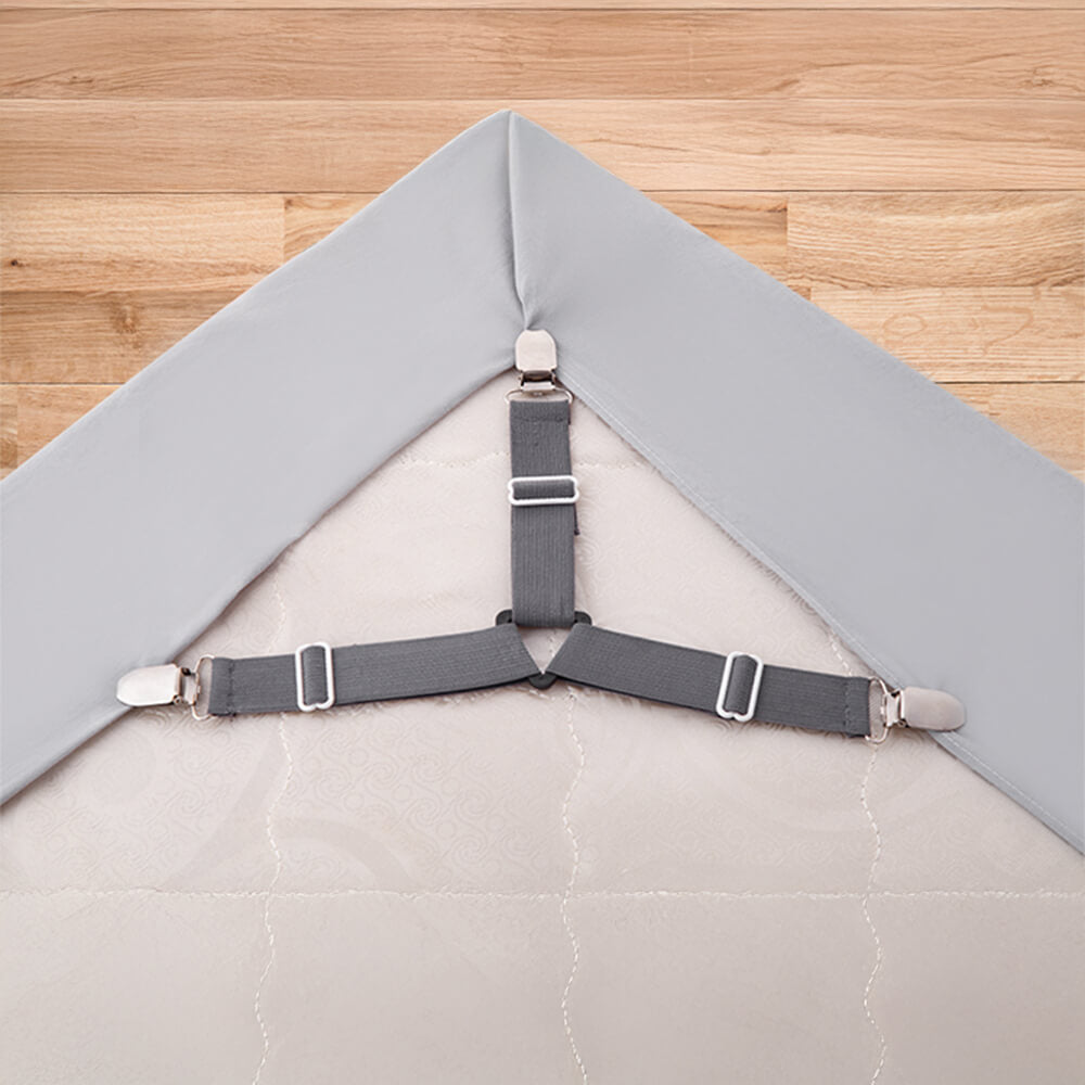 Close-up of a white adjustable bed sheet strap with strong metal clips for mattress linen