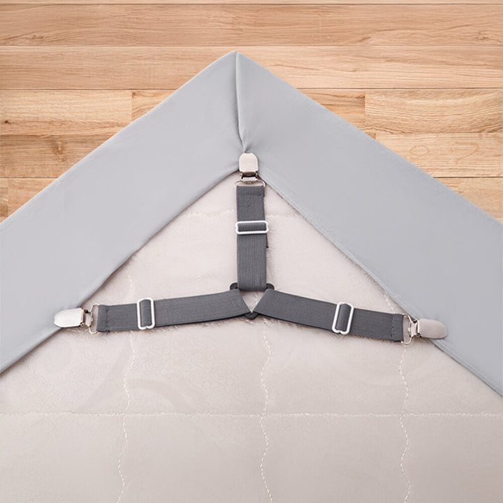 Close-up of a white adjustable bed sheet strap with strong metal clips for mattress linen