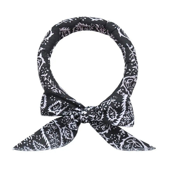 Adjustable pet cooling scarf draped over a paw, highlighting its lightweight fabric, essential pet accessory
