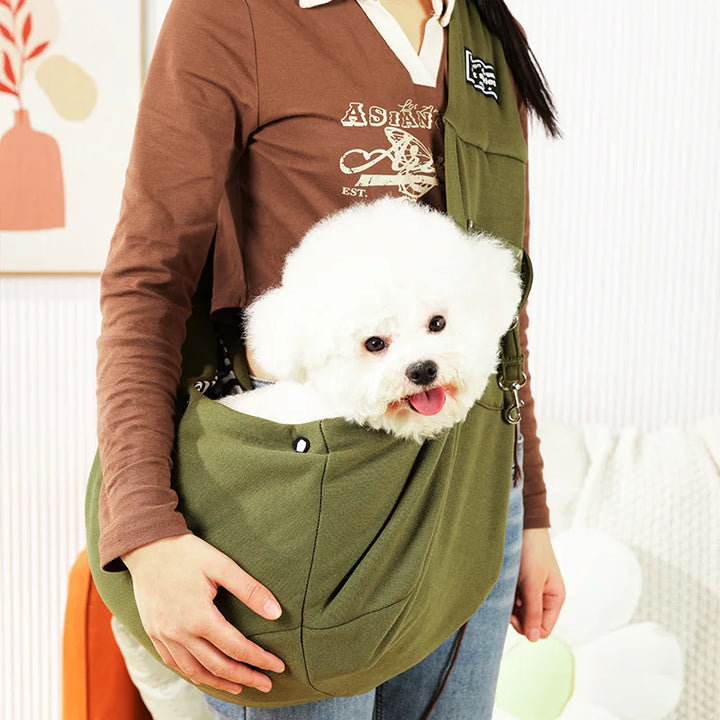 Adjustable pet sling carrier for comfortable, hands-free travel with small dogs or cats.