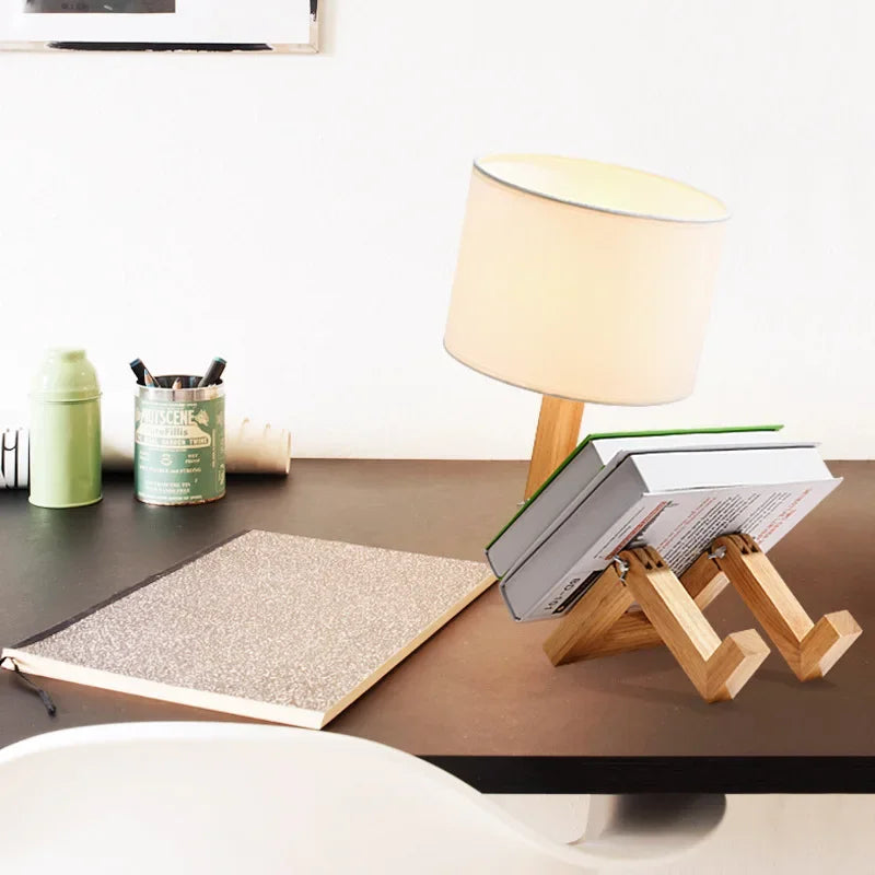 Decorative wooden robot lamp with a fabric shade, adjustable limbs, and a built-in shelf for storage.