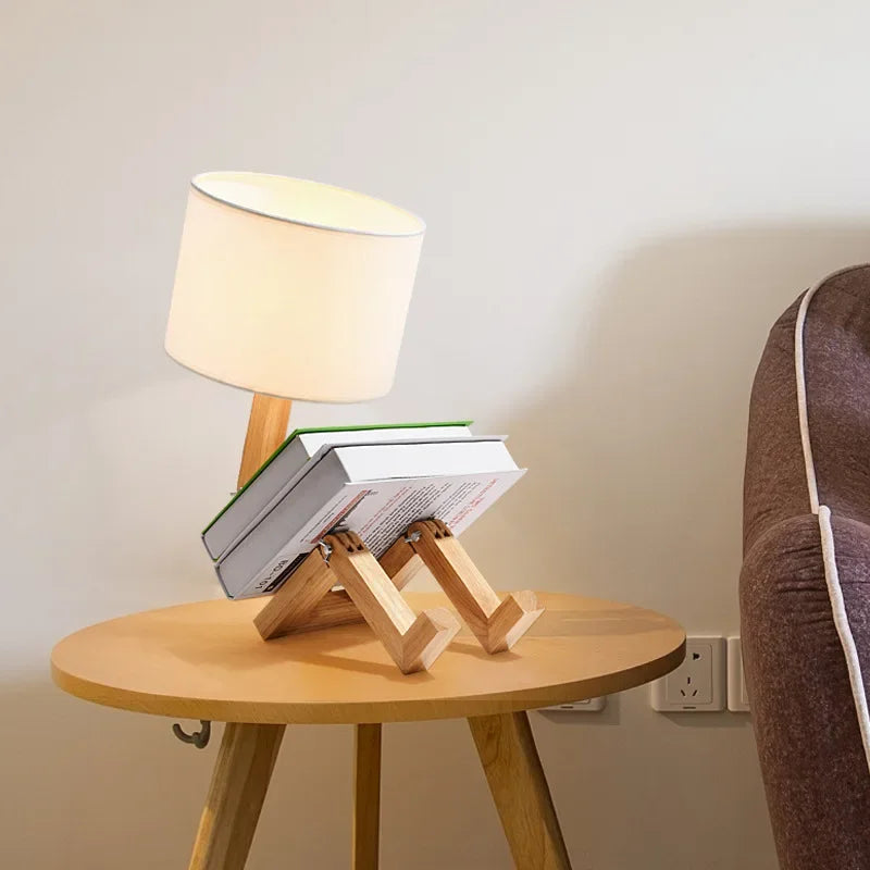 Functional adjustable wooden lamp for desks, shaped like a robot, with an convenient storage shelf.