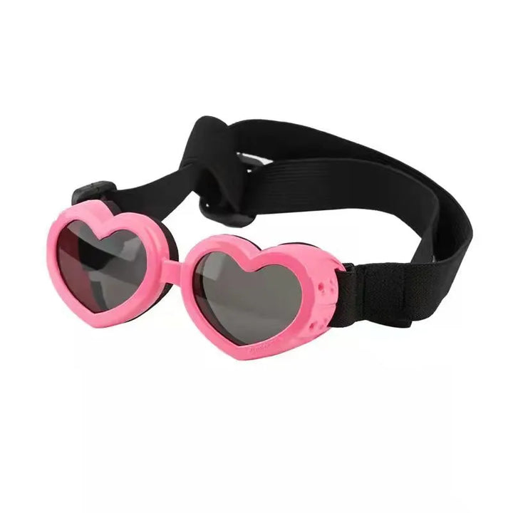 Dog enjoying outdoor activities with stylish red heart-shaped UV protection sunglasses for eye care.