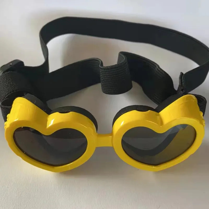 Puppy modeling unique heart-shaped pet sunglasses, offering UV protection and a trendy look.