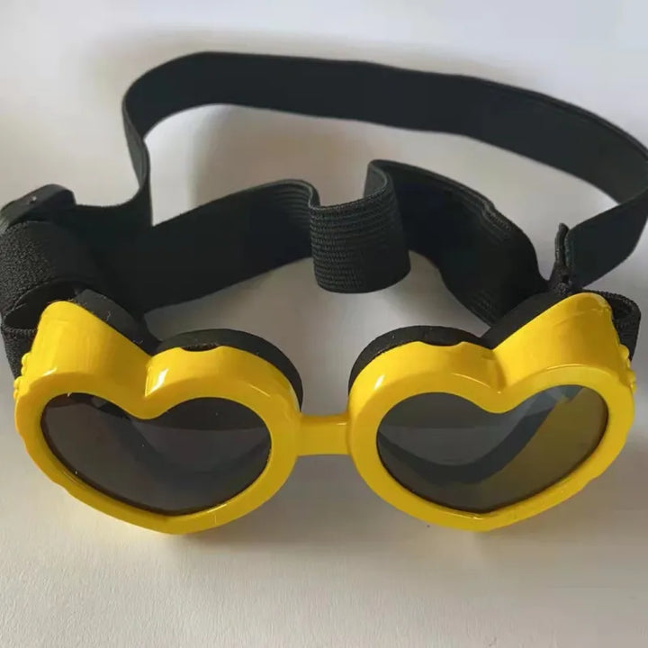 Puppy modeling unique heart-shaped pet sunglasses, offering UV protection and a trendy look.