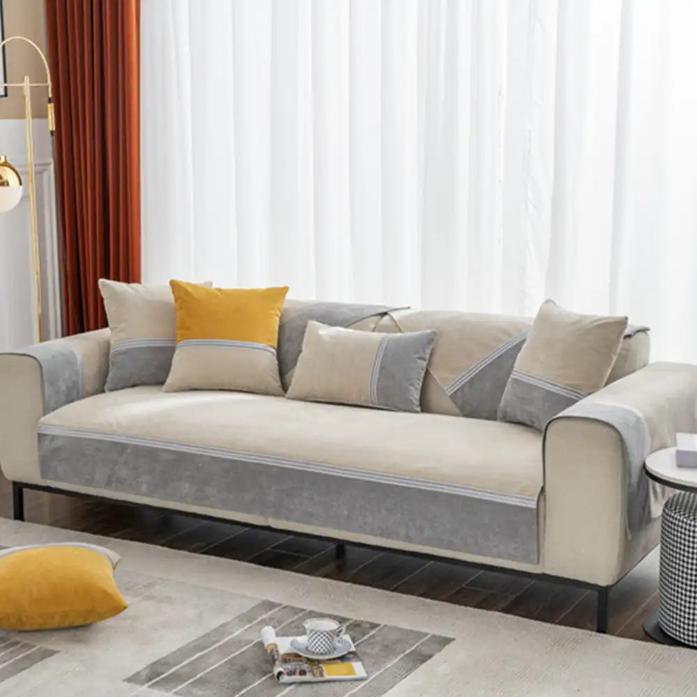 Reversible colorblock couch protector on a sofa, highlighting its versatile and durable design.