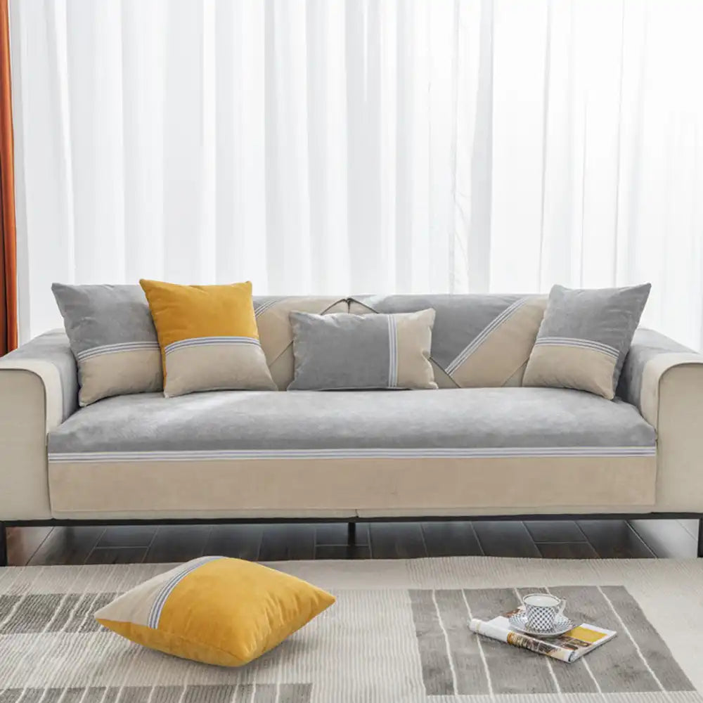 Overhead view of an anti-slip, pet-friendly colorblock couch cover fitting a three-seater sofa.