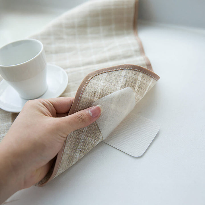 Close-up of clear adhesive gripper stickers discreetly holding a couch cover in place.