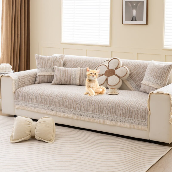 Sectional couch slipcover in a neutral color, featuring anti-slip backing and elegant tassel accents.