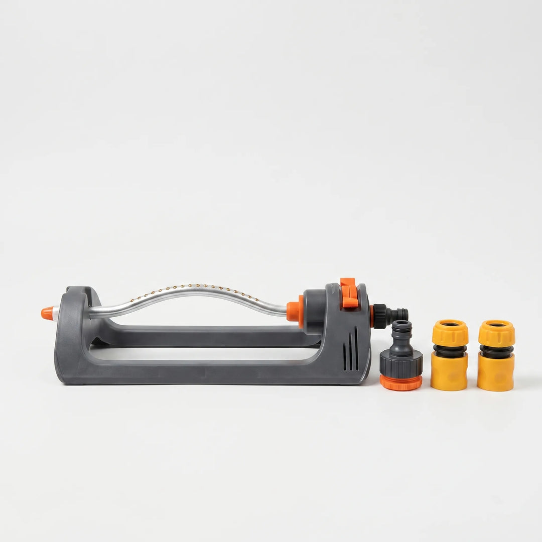 Modern automatic oscillating sprinkler efficiently irrigating a vibrant green lawn in a sunny backyard.