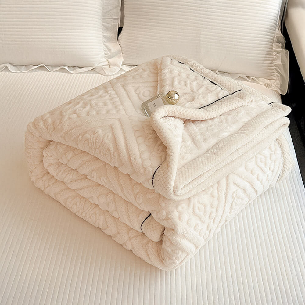 Bedroom scene with a Baroque embossed milk velvet fleece blanket prominently displayed, luxury