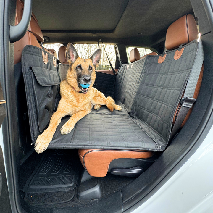 Black dog backseat extender with door covers, protecting car interior & ensuring pet safety during travel.