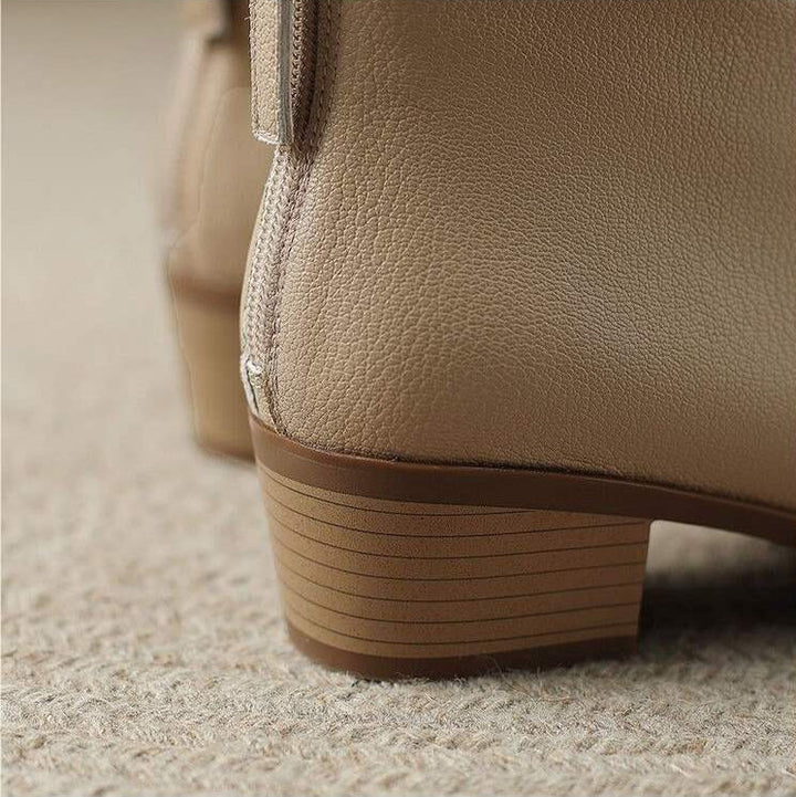 Premium material texture on chic black women's pointed toe slip-on ankle boots. Comfortable everyday design.