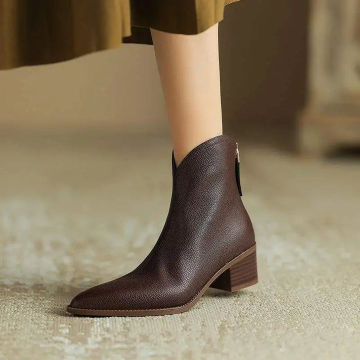 Front view of chic women's black pointed toe ankle boots. Perfect low heel slip-ons for office & fall fashion.