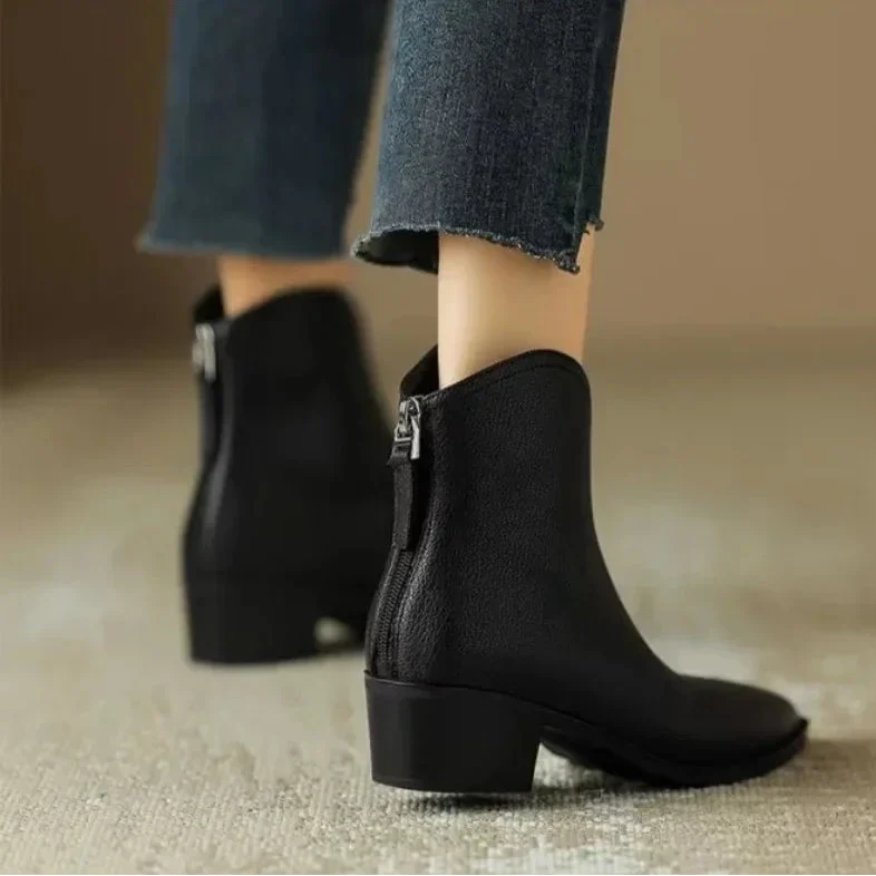 Close-up of the elegant pointed toe on black women's slip-on ankle boots. Stylish office & fall footwear.