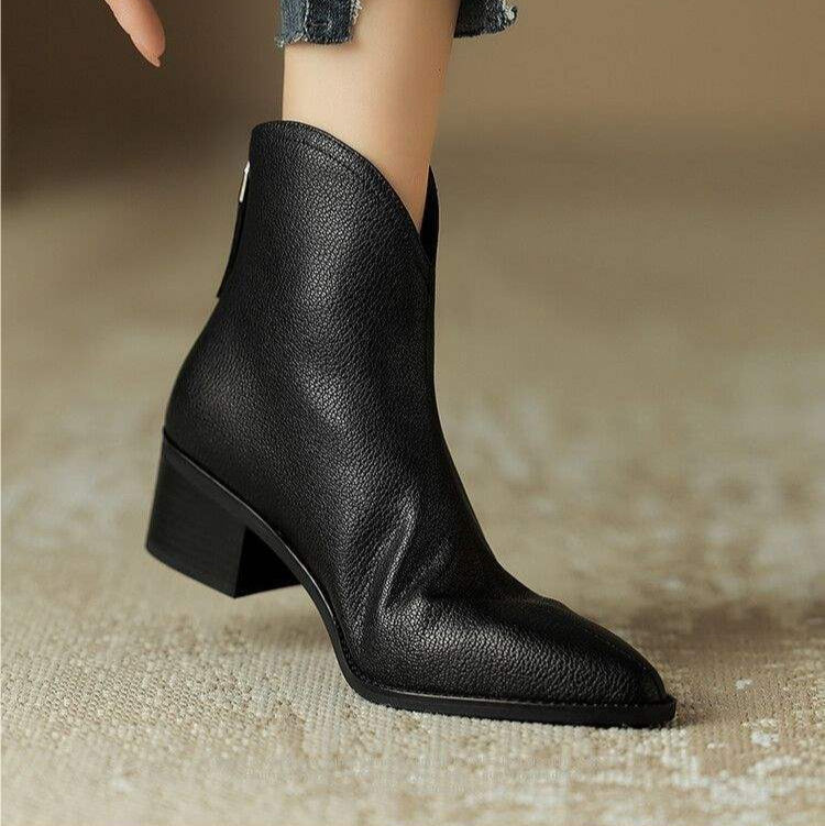 Detail of comfortable low block heel on versatile women's pointed toe slip-on ankle boots. Everyday essential.
