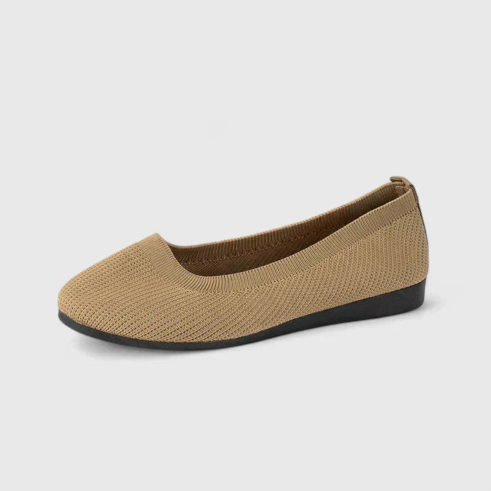 Woman's feet wearing black orthopedic slip-on shoes, highlighting casual style & posture support for walking.