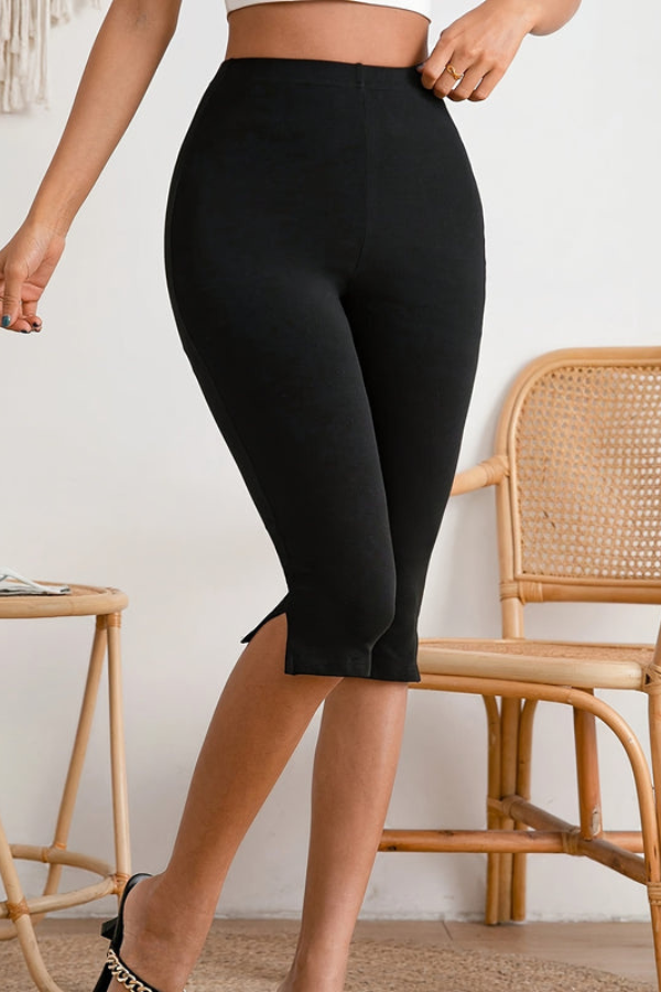 Stylish women's black slim-fit cropped stretch pants, featuring a modern slit hem, great for summer fashion.