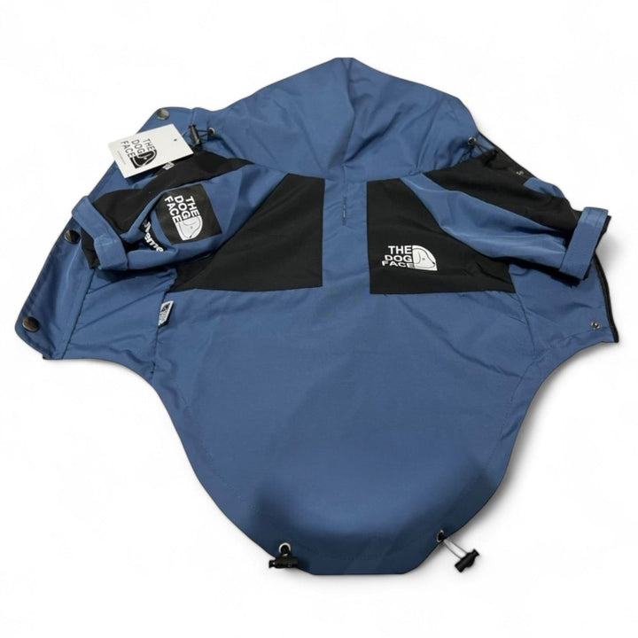 Folded blue waterproof dog jacket with hood, perfect dog raincoat for outdoor adventures.