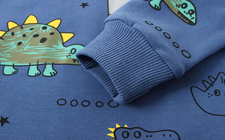 Little boy smiling and playing in his comfy dinosaur adventure outfit set, bright and active.