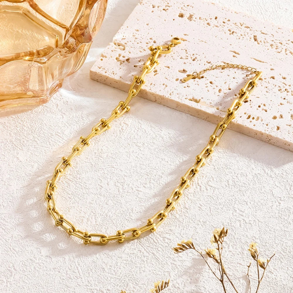 Detailed view of a women's gold link chain, emphasizing the unique design of the jewelry set.