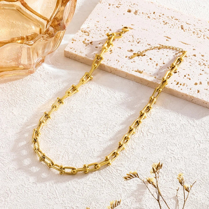 Detailed view of a women's gold link chain, emphasizing the unique design of the jewelry set.