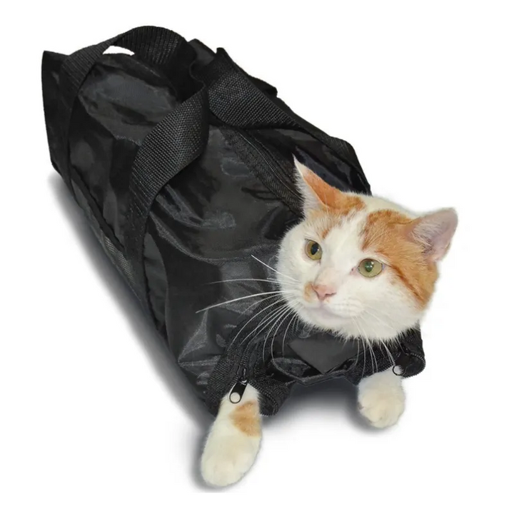 Hands gently holding a cat in a restraint bag, demonstrating how to trim claws without struggle.