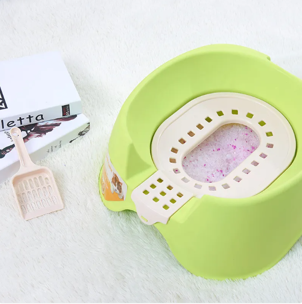 Close-up of a cat litter tray's textured interior with a convenient scoop for pet supplies