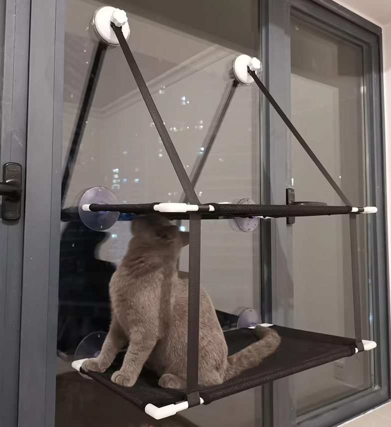 Cat window lounger with suction cups, offering a space-saving perch for feline relaxation and sunbathing.