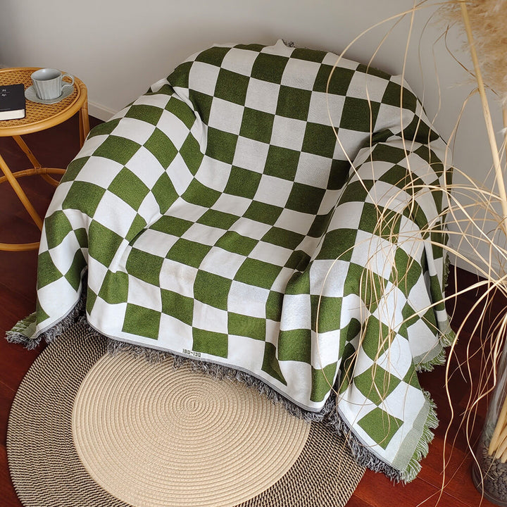 Versatile checkerboard couch throw with playful fringe, offering both style and protection for furniture.